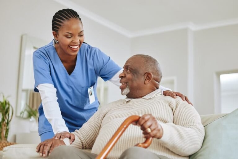 caregiver assisting a patient get up from seated position 768x512